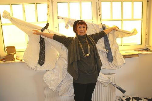 Ronny hebt ihre Arme. Im Hintergrund sind Hemden welche das selbe tun.